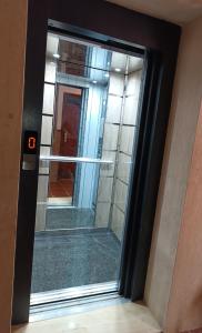 a glass door leading into a building with a mirror at Residence Family OULANTI in Martil