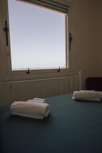 two towels sitting on a bed in a room with a window at [La Terrazza di Chiavari] in Chiavari
