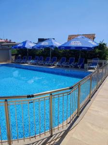 una gran piscina con sillas y sombrillas en Vemara City Apart Hotel en Varna