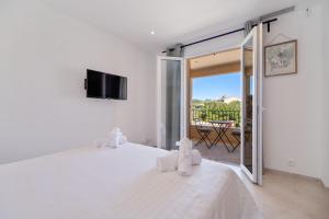 a bedroom with a white bed with a sliding glass door at Deux suites haut standing duplex proche St. Tropez in Cogolin