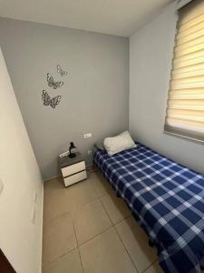 um pequeno quarto com uma cama e uma janela em Piso familiar 2 dorm. Cocina em Los Realejos