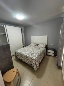 a bedroom with a bed and a table and a chair at Piso familiar 2 dorm. Cocina in Los Realejos