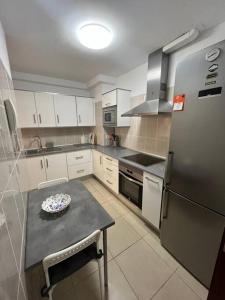 a kitchen with a refrigerator and a table with a plate on it at Piso familiar 2 dorm. Cocina in Los Realejos
