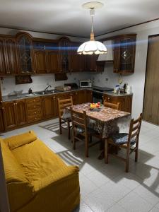 una cucina con tavolo, sedie e divano di Casa Fontanelle a Burgio