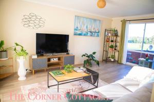 a living room with a tv and a coffee table at Corner Cottage in Dandenong