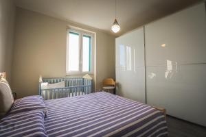 a bedroom with a blue and white striped bed at Appartamento nuovissimo con parcheggio gratuito in Massa