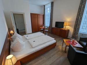 a bedroom with a large bed and a living room at Badhotel Bad Brückenau in Staatsbad Brückenau
