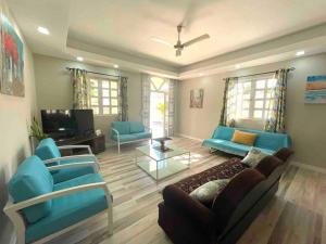 a living room with blue couches and a tv at Tropical getaway villa in Pereybere