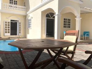 a wooden table and chairs in front of a house at Tropical getaway villa in Pereybere