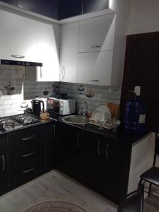 een keuken met een wastafel en een fornuis top oven bij GREEN HAUS FOR YOU in Sergeli