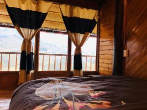 a bedroom with a bed and windows with a view at Sần's House in Lao Cai