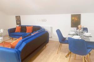 a living room with a blue couch and a table at Spacious City Centre Apartment near Lakeside in Stifford