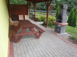 - une table de pique-nique et un poêle à bois sur la terrasse dans l'établissement Domek w Bieszczadach u Ani Apartament 3, à Uherce Mineralne