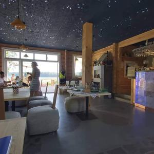 Cette chambre dispose d'une cuisine avec une table et des personnes. dans l'établissement Namelis su ofuro vonia prie Plateliu ežero, à Medsėdžių