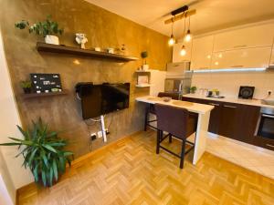 a kitchen with a table and a tv on a wall at Apartman ANN in Pančevo