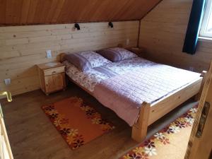 - une chambre avec un lit dans une cabane en rondins dans l'établissement Domek w Bieszczadach u Ani Apartament 3, à Uherce Mineralne