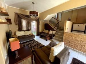 a living room with a couch and a staircase at Cozy Townhouse, with back yard (98) in Sheikh Zayed