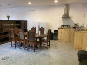 a kitchen with a wooden table and chairs at Arcanjo Hostel in Braga