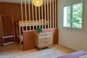 a room with a bunk bed and a dresser and a window at Gîte L'Attrape-Rêve in Saint-Paul-Trois-Châteaux