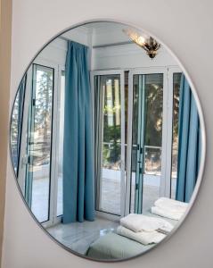 Unique, elegant Bourtzi View Villa في نافبليو: مرآة تعكس غرفة مع ستائر زرقاء