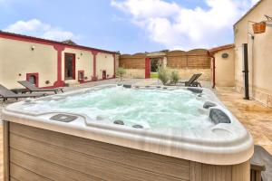 een hot tub in de achtertuin van een huis bij Hôtel & SPA Château de La Côte - Brantôme in Biras