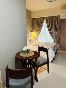 a room with a table and a bed and a table and chairs at Inspiria Abreeza Davao in Davao City
