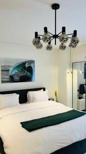 a bedroom with a large white bed with a chandelier at The Signature Apartments, Accra Ghana in Accra