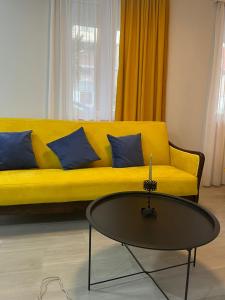a yellow couch in a living room with a coffee table at Apartment Fumfula in Batumi