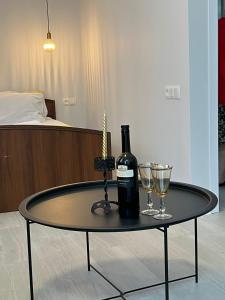 uma mesa com uma garrafa de vinho e dois copos em Apartment Fumfula em Batumi