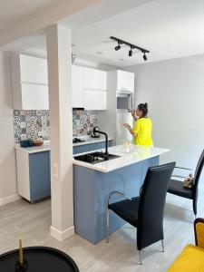 a woman standing in a kitchen with a sink at Apartment Fumfula in Batumi