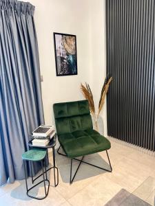 a green chair and a table in a room at The Signature Apartments, Accra Ghana in Accra