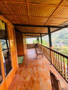 a porch of a wooden cabin with benches on it at Sần's House in Lao Cai