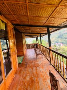 un porche de una cabaña de madera con bancos. en Sần's House, en Lào Cai