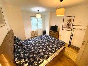 a bedroom with a bed with a blue blanket at Apartman ANN II in Pančevo