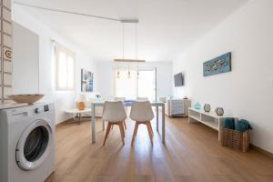 a kitchen and dining room with a table and a washing machine at Apartamentos Catalina in Es Pujols