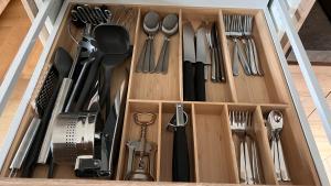 a wooden drawer with utensils in it at Hello Mountains Apartaments Sinaia in Sinaia