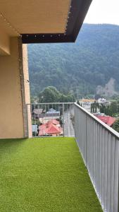 a balcony with green grass and a view of a building at Hello Mountains Apartaments Sinaia in Sinaia