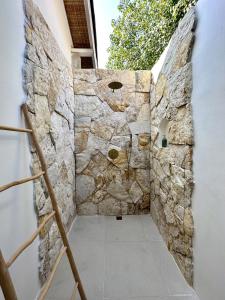 un mur en pierre dans un couloir d'un bâtiment dans l'établissement Rumah Canaria Bungalow, à Gili Trawangan