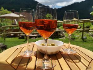 tres copas de vino sentadas en una mesa de madera en Waldhütte Glück Auf, en Nötsch bei Bleiberg