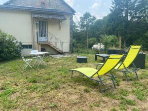 two chairs and a table in the yard of a house at Petite maison en Auvergne in Giat