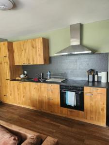 cocina con armarios de madera y horno con fogones en Guest Flat in the Swiss Mountains (Lake View), en Seelisberg