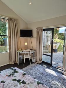 um quarto com uma cama e uma secretária com uma televisão em Haven Sanctuary Suite with Private Entrance em Queenstown