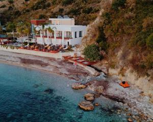 an aerial view of a building on a cliff next to the water at Oniro in Sea & Sun ADULTS ONLY in Himare