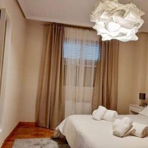 a bedroom with two beds and a chandelier at Pilatos in Zamora
