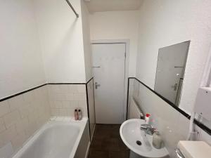 a bathroom with a tub and a sink and a toilet at Neasden, Dollis Hill London Apartment in London