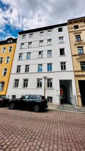 een zwarte auto geparkeerd voor een gebouw bij Apartment FLORA in Halle an der Saale in Halle an der Saale