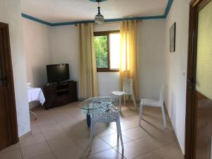 a living room with a table and chairs and a tv at Vila Demo in Vlorë
