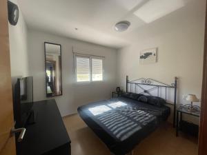 a bedroom with a black bed and a mirror at Condado De Alhama Golf Resort 2 Bedroom Apartment Jardine 13 in Murcia