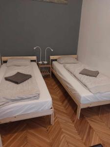 2 camas en una habitación con suelo de madera en Sega Rally Apartment, en Budapest