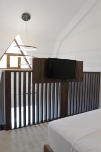 a bedroom with a bed and a tv on a fence at Hotel McPietroasa in Haleş